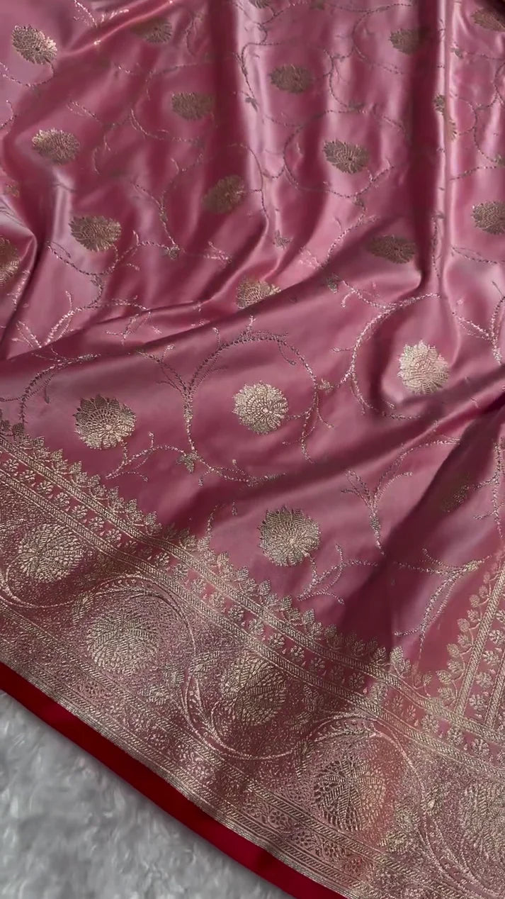 Pink fabric with gold embroidery on a textured surface