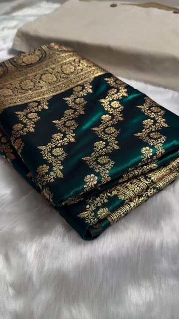Green fabric with gold embroidery on a white surface