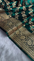 Green fabric with gold embroidery on a white background