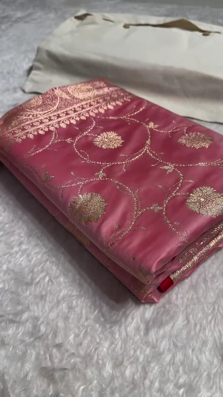 Pink fabric with gold embroidery on a textured surface
